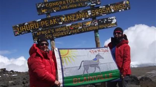 Monique Proulx brandit le drapeau des scouts au Kilimandjaro